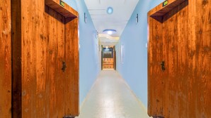 A hallway with wooden doors and a light-colored floor. - Fabexpress Regal (Indore)
