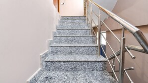 Una escalera con escalones de granito y barandillas de acero inoxidable.