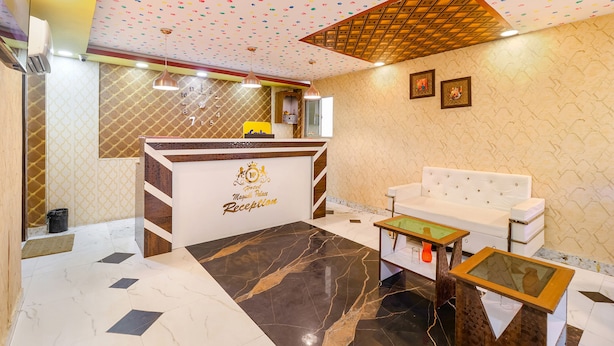 A hotel reception area with a marble floor, a reception desk, a white sofa, and a patterned ceiling. - Fabhotel Magadh Palace (Danapur)