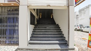 Gradi leading to l'entrada d'un edifici, amb una reixa metàl·lica i un sòl enrajolat.