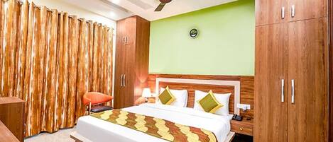 A bedroom with a bed, a nightstand, a chair, a ceiling fan, and wooden wardrobes.