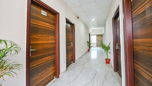 Un couloir avec des portes en bois, numérotées 204, et des plantes en pot.