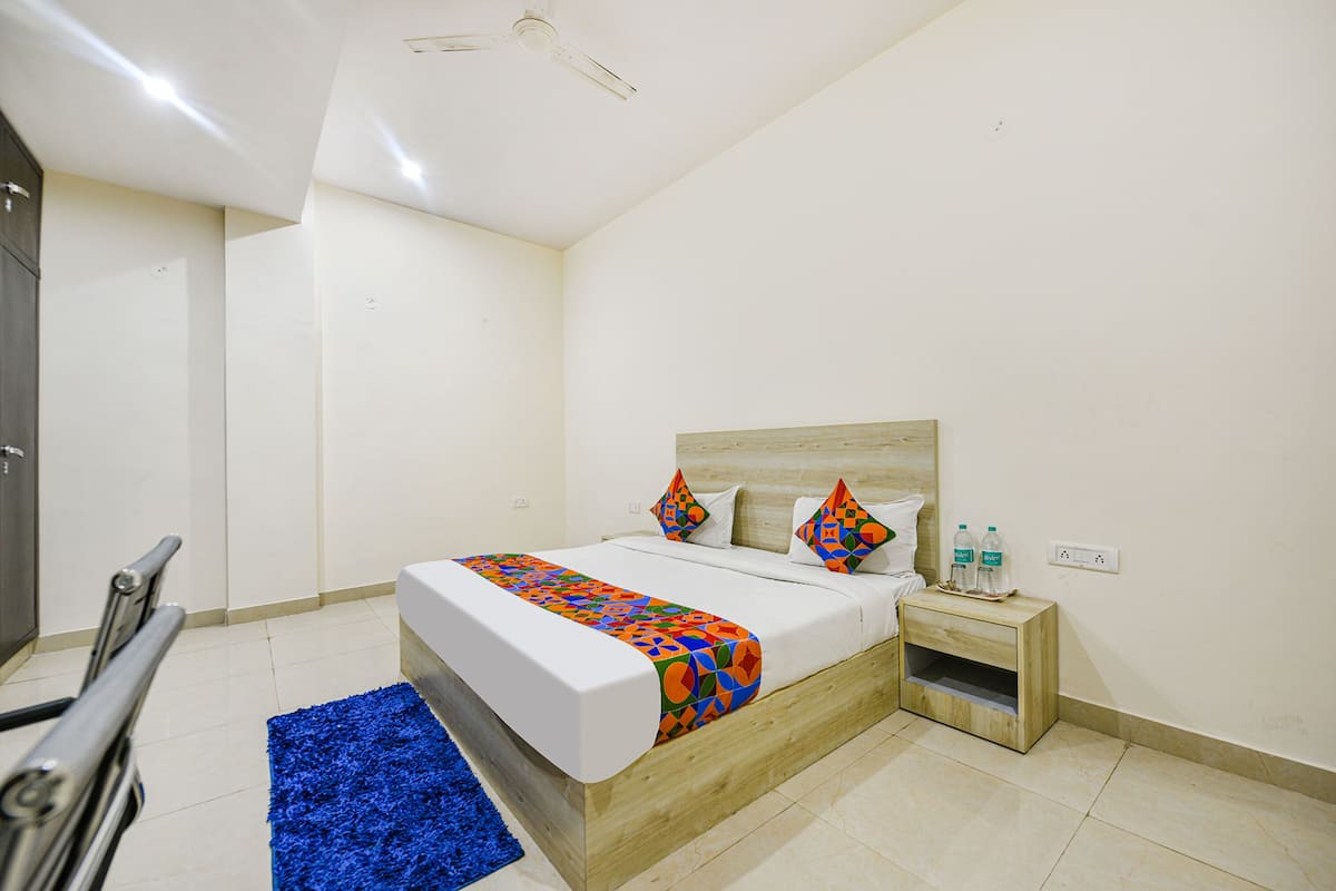 Une chambre à coucher avec un lit, une table de chevet, une commode et un tapis bleu.