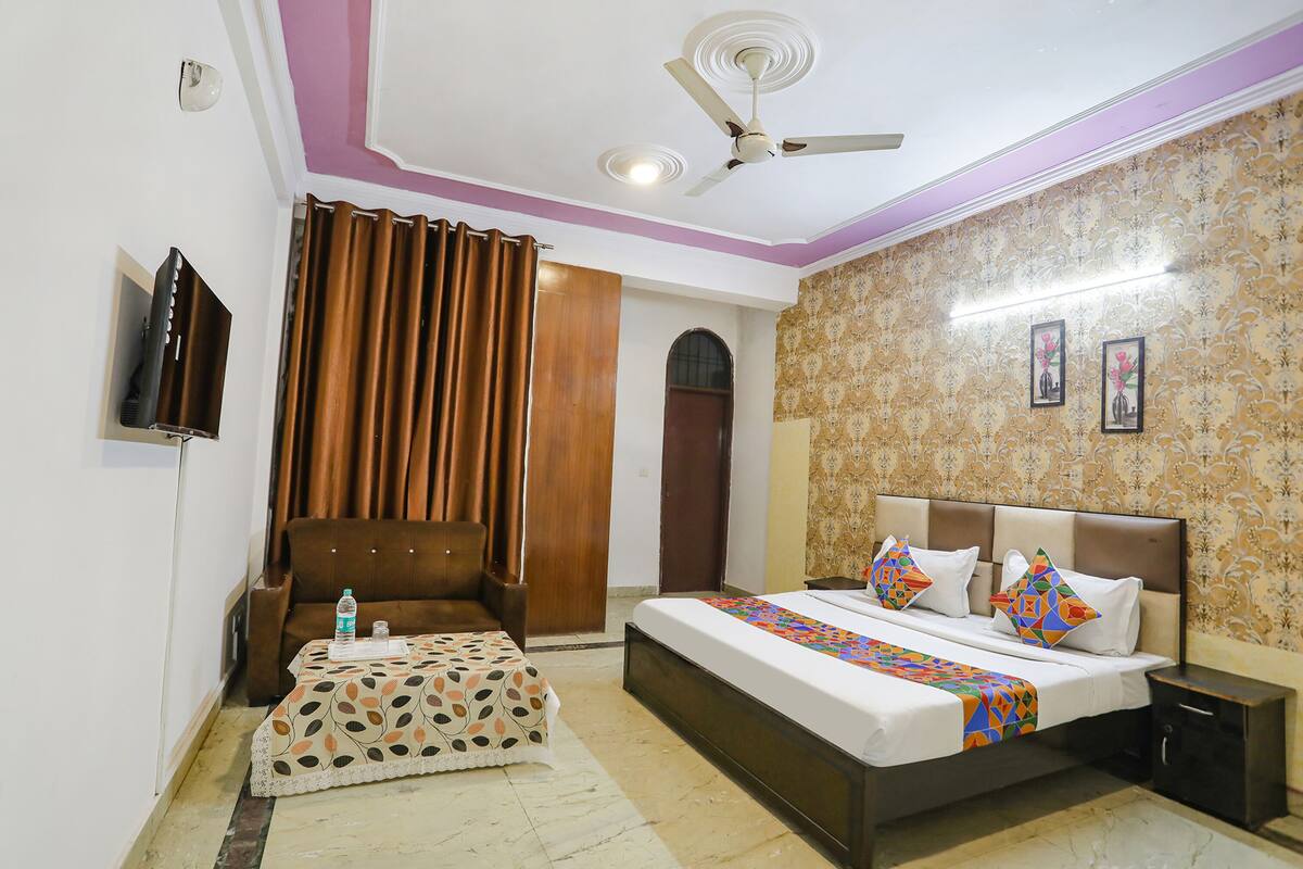 A bedroom with a bed, a ceiling fan, a TV, and a wardrobe.