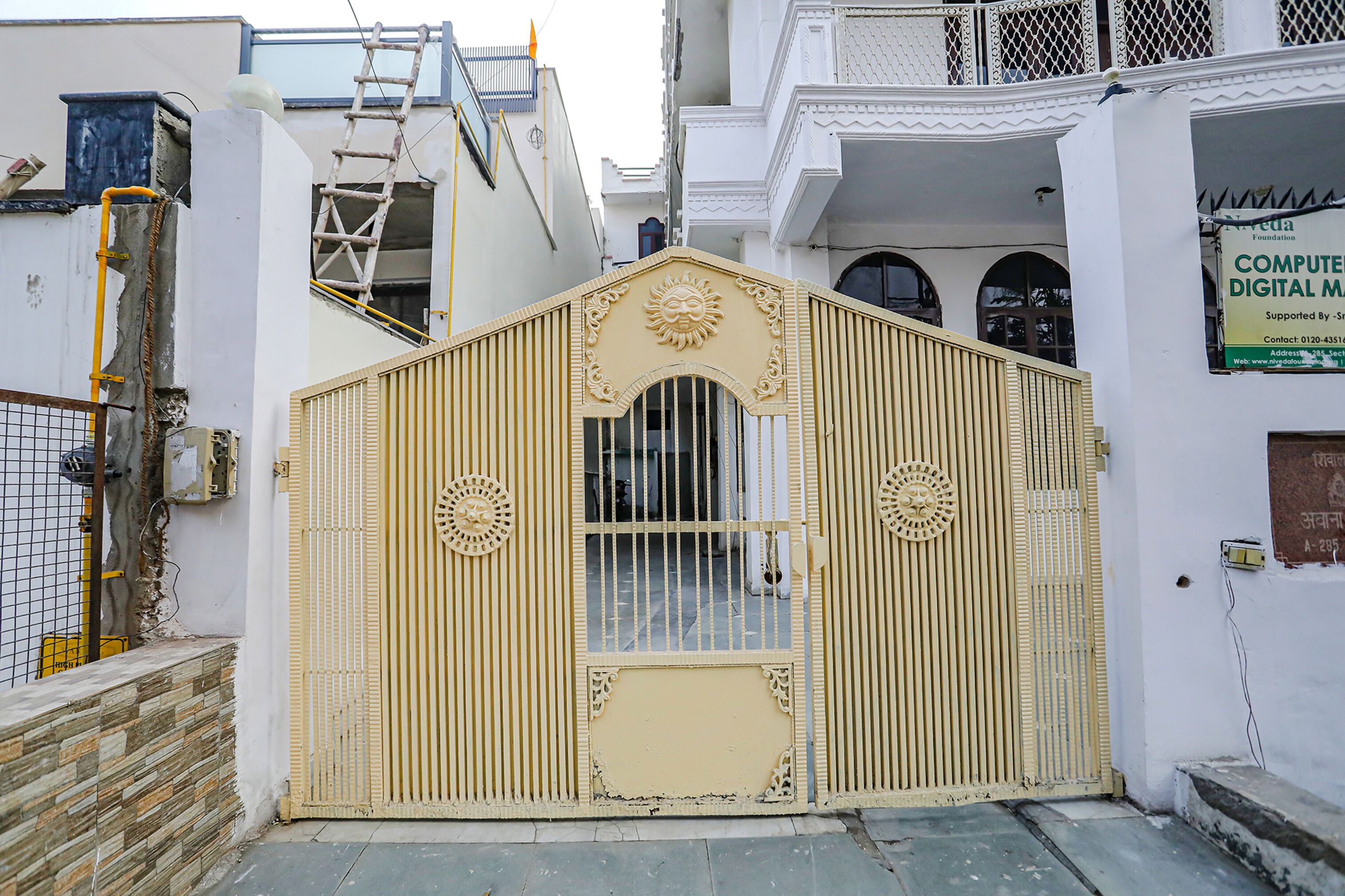 A gated entrance with a decorative arch and a signboard for a digital media foundation.