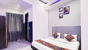 A modern hotel room with a large bed, a headboard, and a shower area. - Fabhotel Season Grand (New Delhi)
