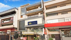 A multi-story hotel with a prominent sign for "Hotel Season Grand" and "FabHotels". - Fabhotel Season Grand (New Delhi)