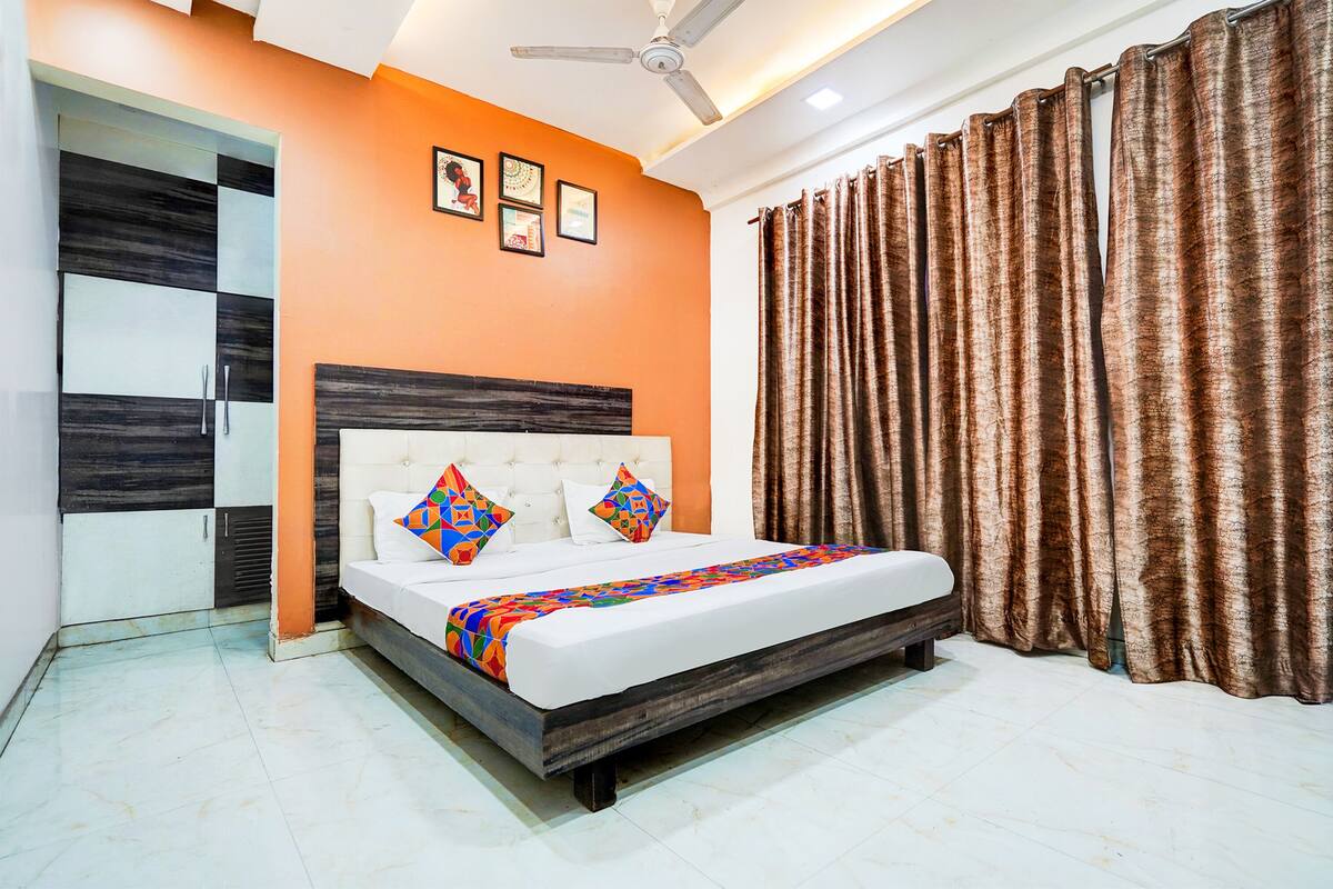 A bedroom with a bed, a ceiling fan, and curtains.