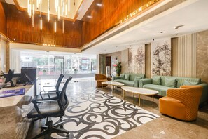 A spacious lobby with a reception desk, seating area, and a large window offering a view of the outside. - Fabhotel Prime Svm Grand (Hyderabad)
