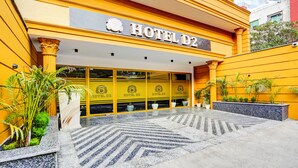 The exterior of HOTEL D2 with a yellow facade, large columns, and potted plants. - FabHotel D2 - Nr Ashok Vihar (New Delhi)