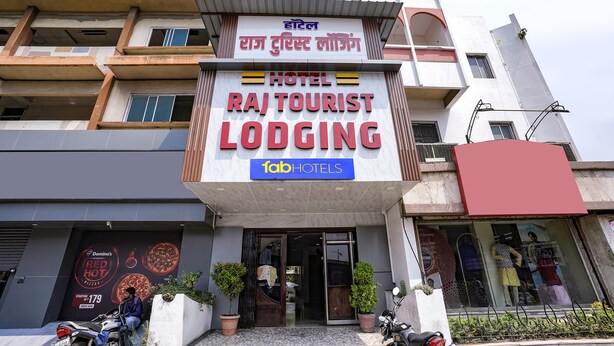 A hotel named Raj Tourist Lodging with a signboard in multiple languages, including English and Hindi. - Fabexpress Raj Tourist (Nashik)