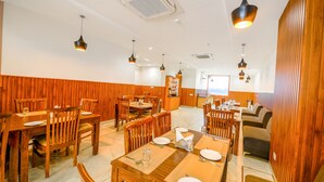 A spacious dining area with wooden walls and tables set for multiple people. - Fabhotel Prime Victoria Regency (Mohali)