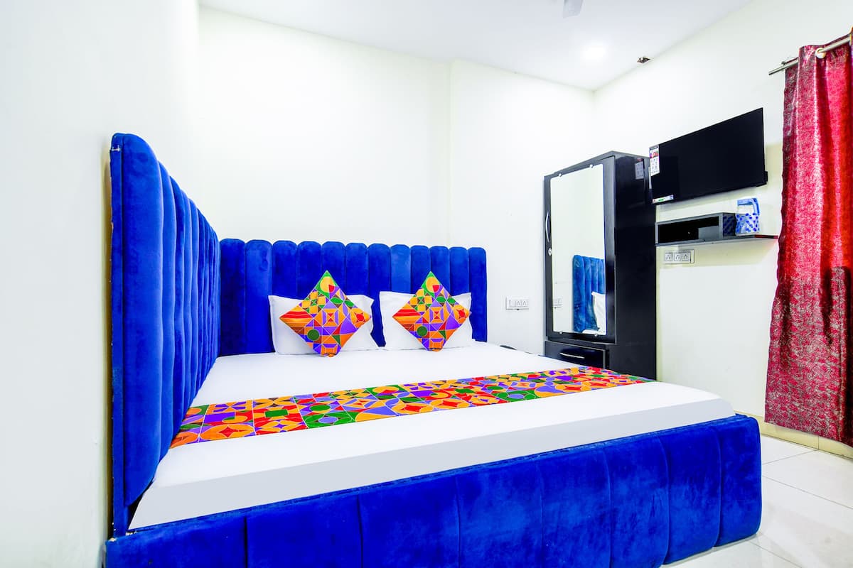 Un dormitorio con cama, televisión y espejo.