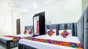 Una habitación de hotel con una cama grande, una mesita de noche, un armario y un espejo.