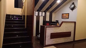 A hotel reception area with a staircase leading to the upper floors. - Fabhotel Ocean Bird (Diamond Harbour)