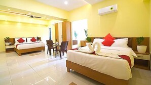 Una habitación de hotel con dos camas, un comedor y un baño.