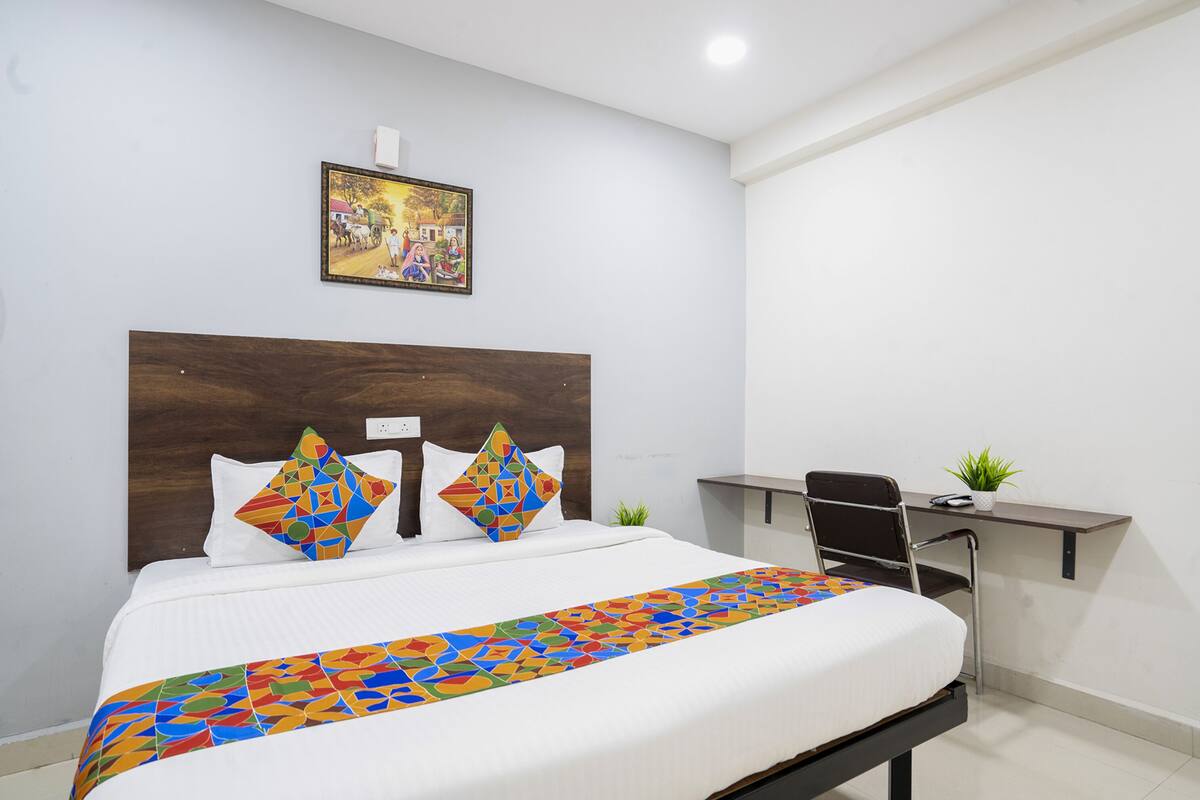 Habitación de hotel con cama, escritorio y silla.