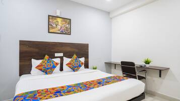 Habitación de hotel con cama, escritorio y silla.
