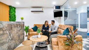 A modern living room with a sofa set, a coffee table, and a potted plant. - FabHotel Grand Aarvi Prime - Nr. Hafeezpet, Madeenaguda (Hyderabad)