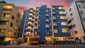 A multi-story hotel with a modern design, featuring balconies and air conditioning units. - FabHotel Grand Aarvi Prime - Nr. Hafeezpet, Madeenaguda (Hyderabad)