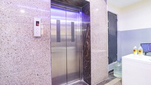 An elevator with a digital display, a water dispenser, and a reception desk. - FabHotel Starhood - Manikonda (Hyderabad)