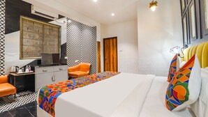 Una habitación de hotel con cama, escritorio, silla y armario.