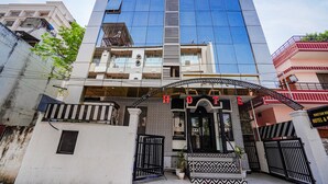 Un hotel moderno con un llamativo letrero de 'fab hotels', una entrada protegida por una reja y un diseño de fachada con motivos.