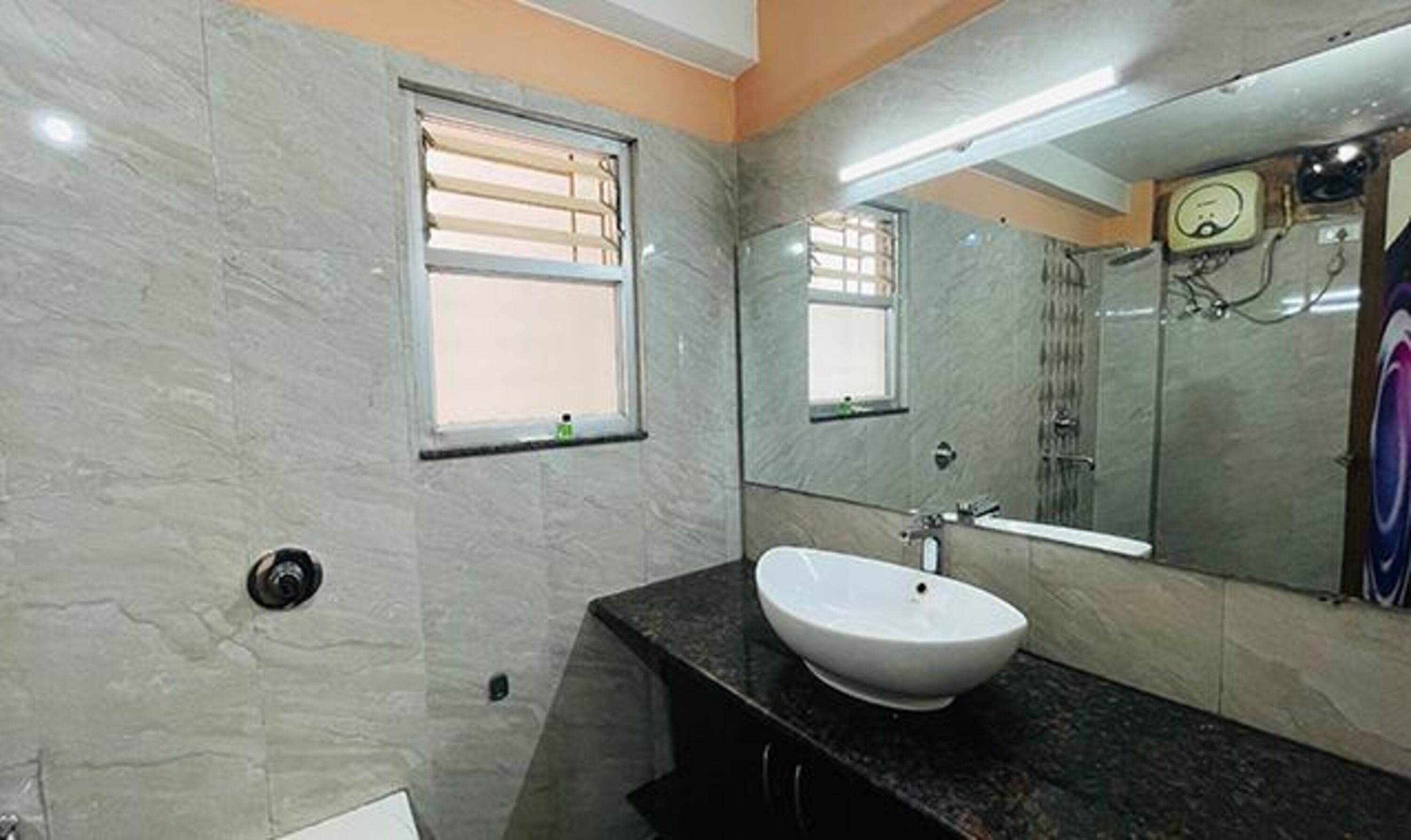 A bathroom with a white sink, a mirror, and a window.
