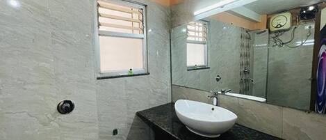 A bathroom with a white sink, a mirror, and a window.