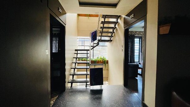 A narrow hallway with a staircase leading to a landing area. - Fabhotel Prime Gananayak (Jalpaiguri)