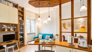 Eine Küche mit Holztisch, blauem Sofa und Frühstücksangebot.
