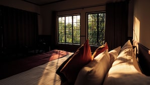 A hotel room with a large bed, a desk, and a window with a view of trees. - The Hive Wayanad By Kondody Hotels (Vythiri)
