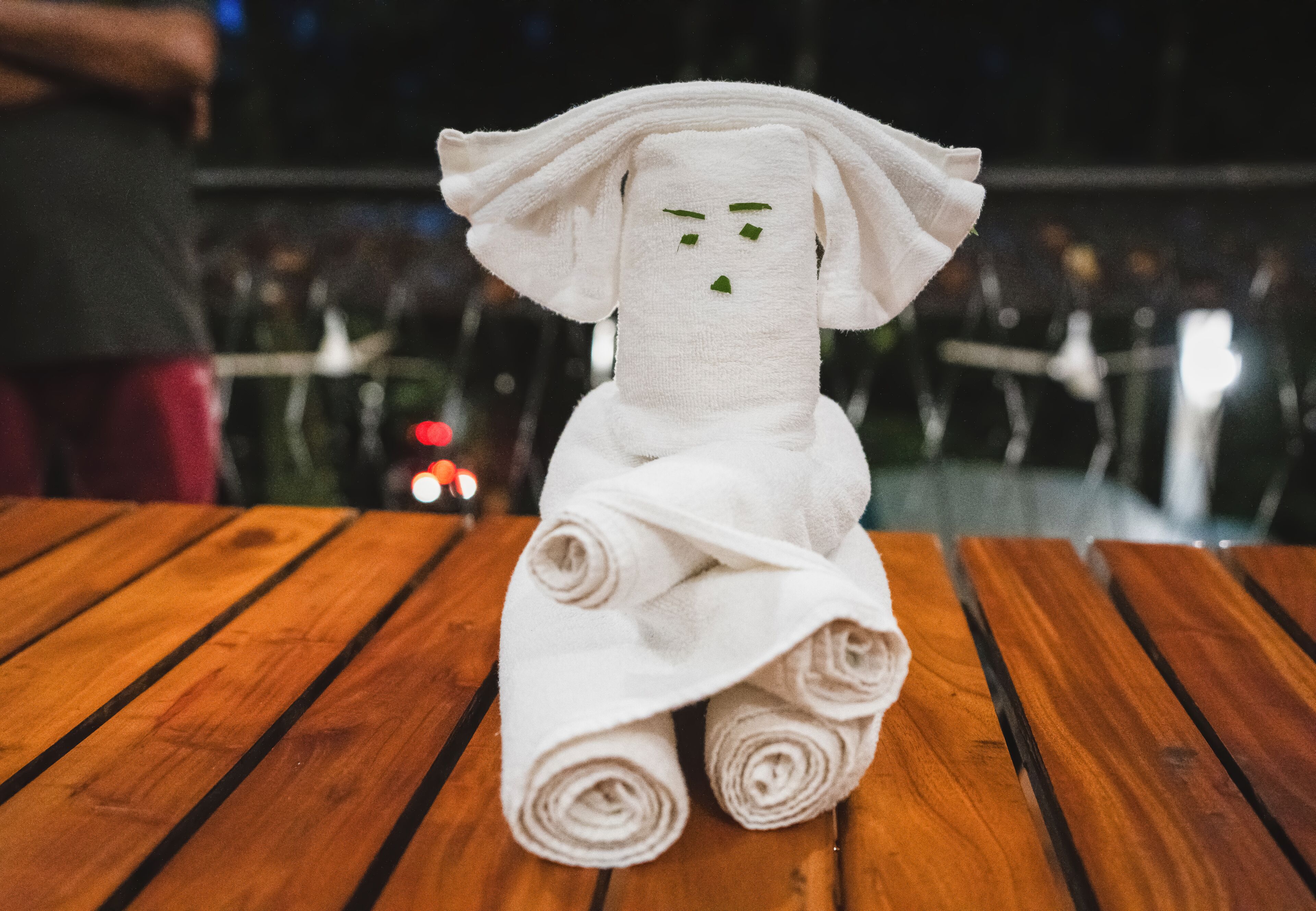A towel sculpture on a wooden table.