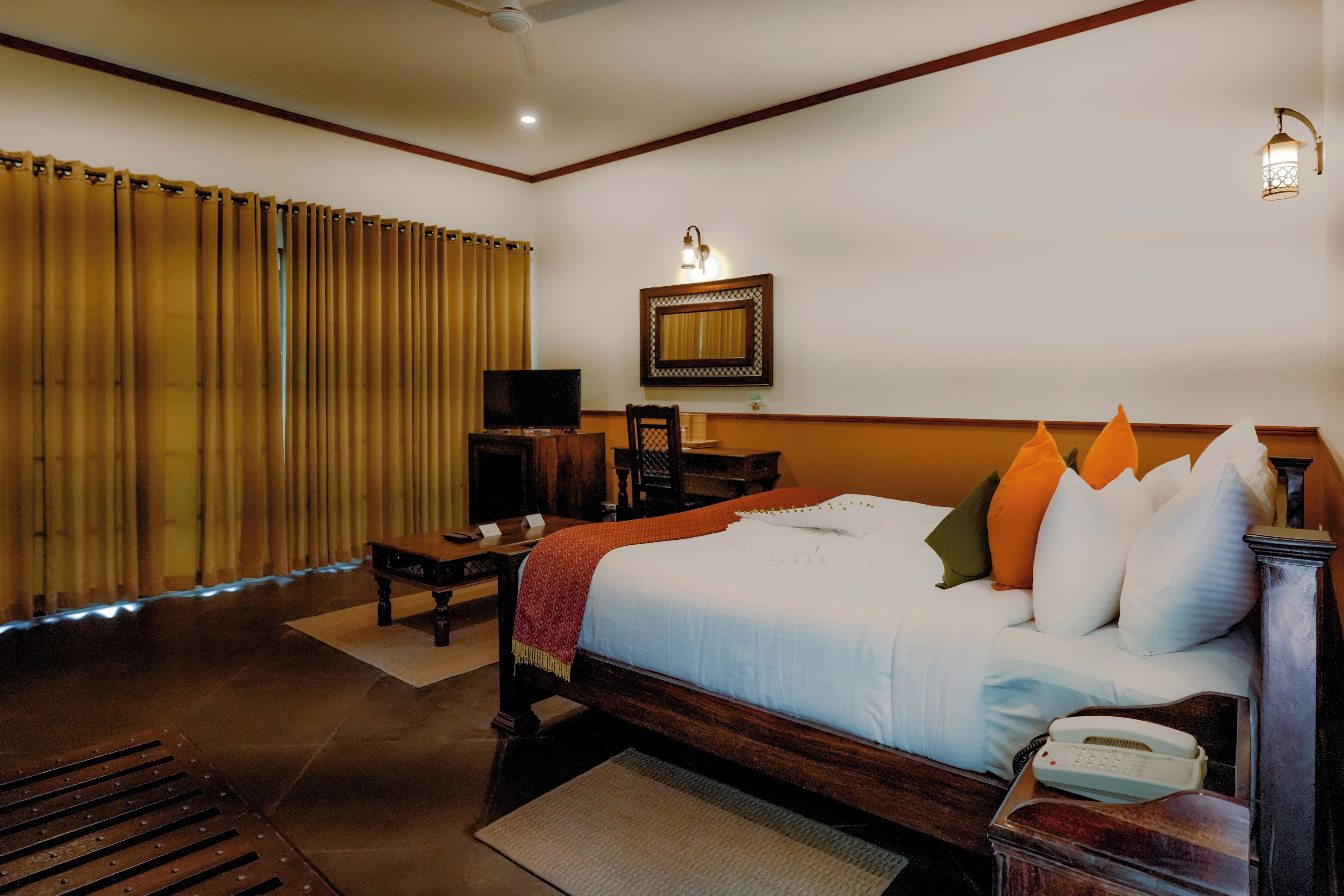 A hotel room with a large bed, a television, a desk, and a chair.