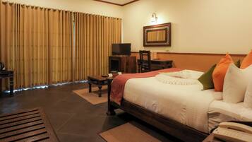 A hotel room with a bed, a desk, a television, and a telephone.