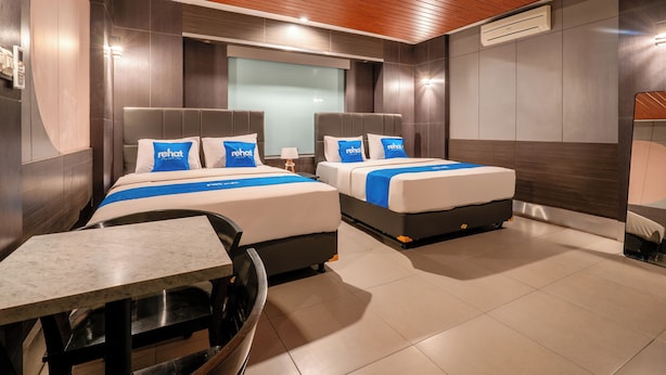 Une chambre d’hôtel avec deux lits, une petite table et une chaise.
