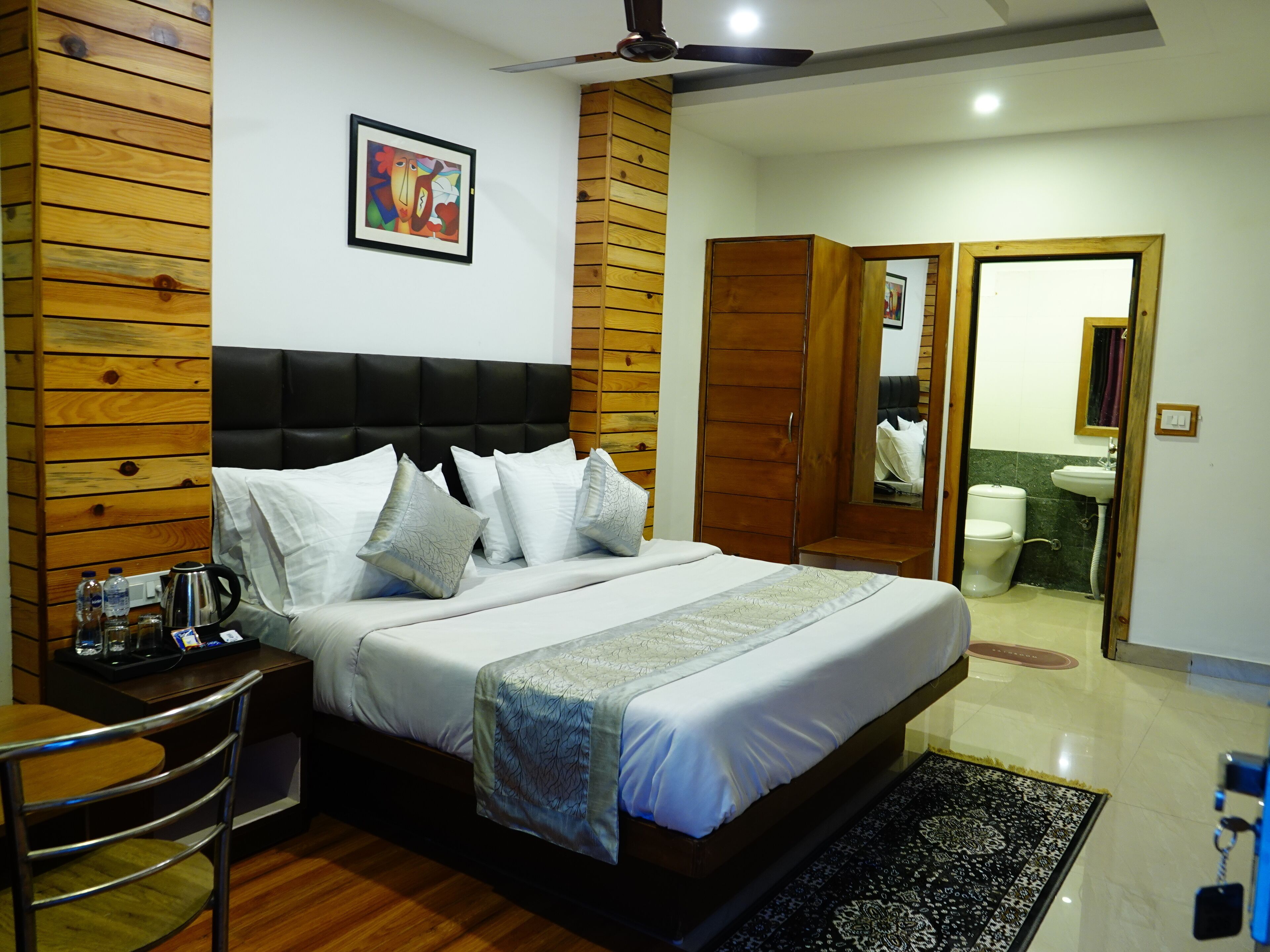A bedroom with a bed, bedside table, and a wooden headboard.