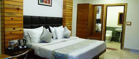 A bedroom with a bed, bedside table, and a wooden headboard.