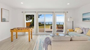 Una sala de estar con una mesa de fútbol, un sofá y vistas al exterior.