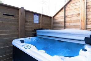 Un jacuzzi con panel de control, rodeado de paredes de madera.