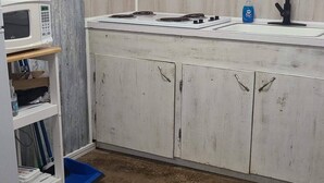 A kitchen with a microwave, sink, and cabinets.