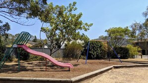 A playground with a slide and swings. - Convenient spot Gosford /near M1HW,CBD,Hospital,Stadium,water view,fishing,pet (West Gosford)