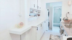 A modern kitchen with white cabinetry, a built-in oven, and a dishwasher. - 2 bedroom cosy guest house in North shore (Auckland)