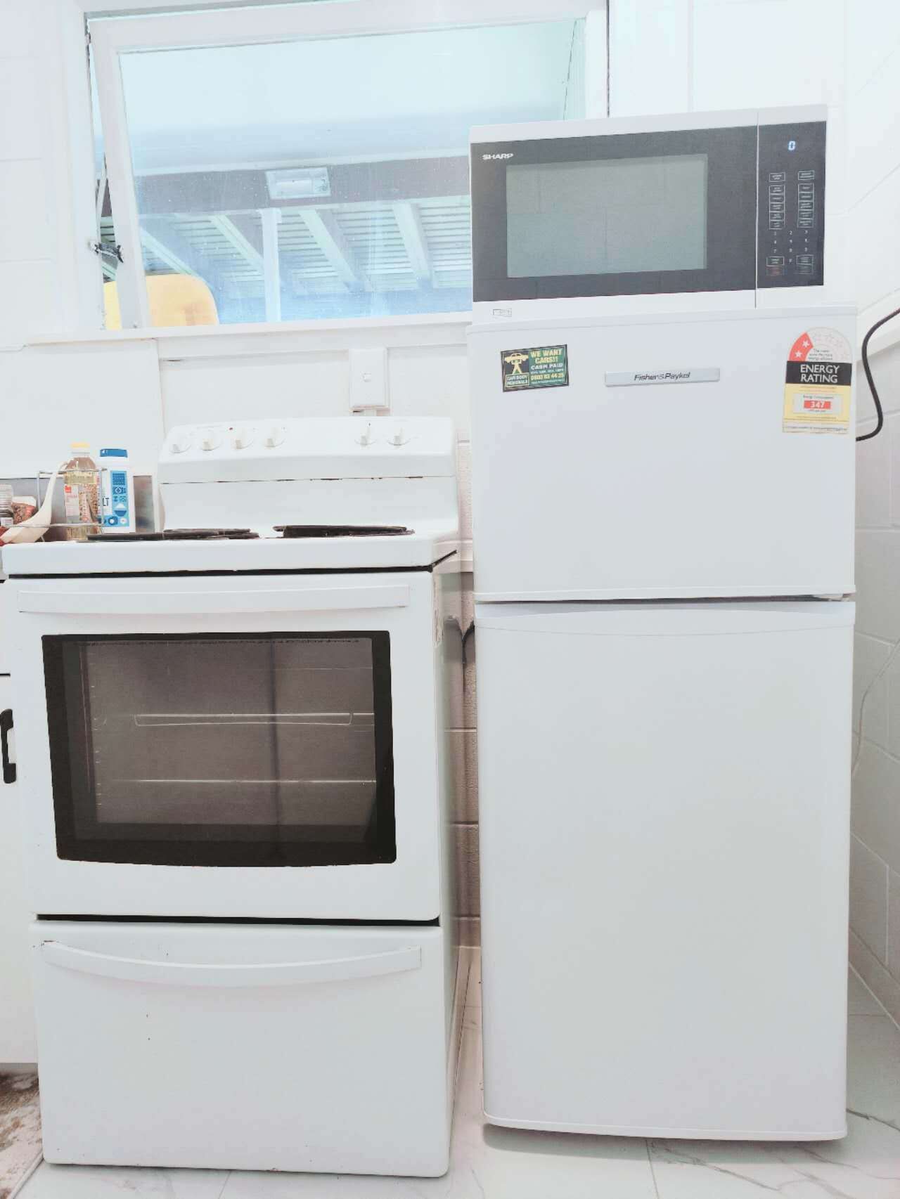 Una cocina con estufa, horno y refrigerador blancos, con etiqueta ENERGY STAR.