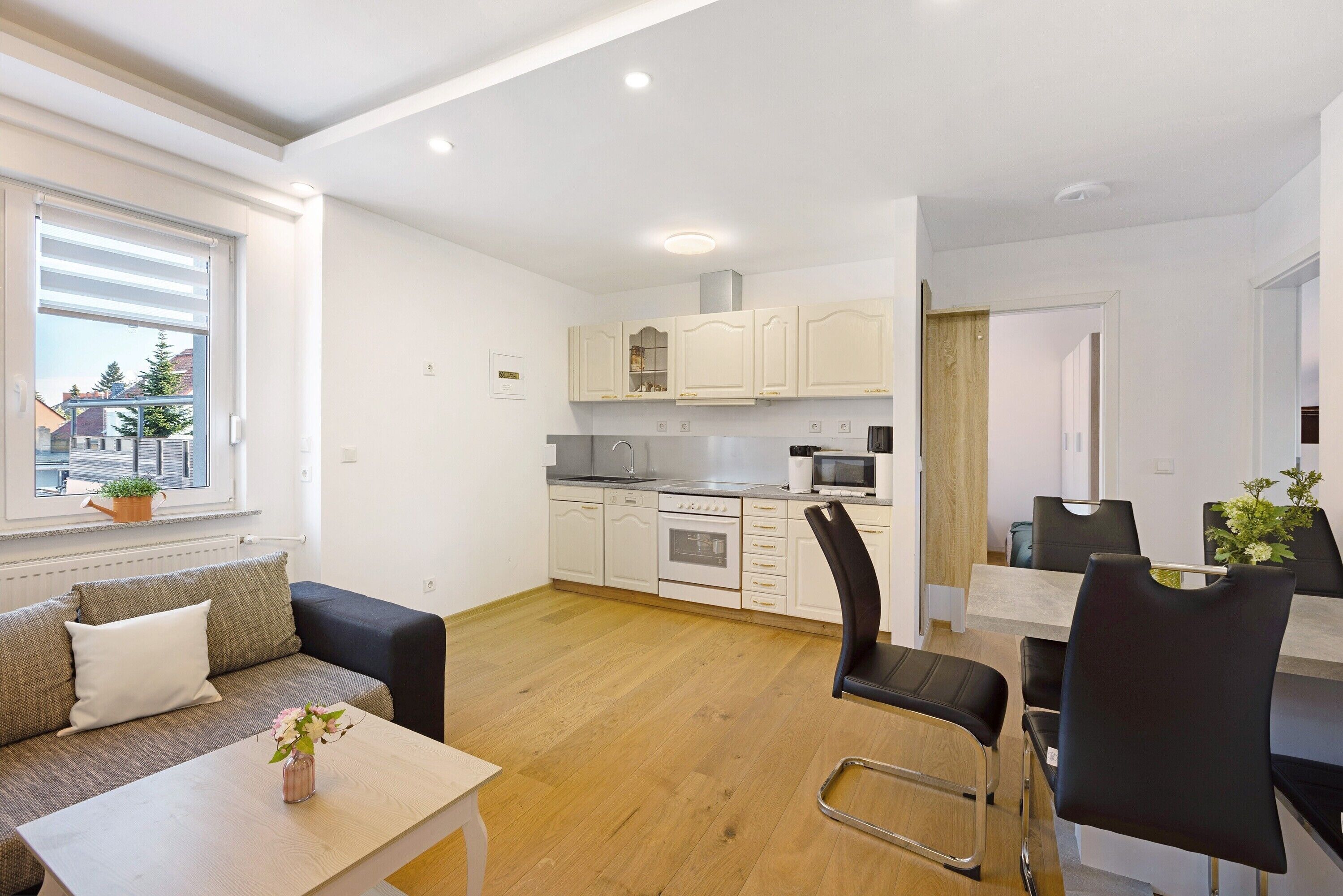 Eine moderne Wohnung mit Küche, Essbereich und einer Couch mit kleinem Tisch.