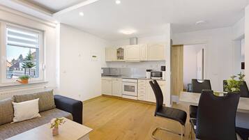 Eine moderne Wohnung mit Küche, Essbereich und einer Couch mit kleinem Tisch.