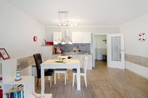Una cocina moderna con alacenas blancas, una isla central e iluminación colgante.