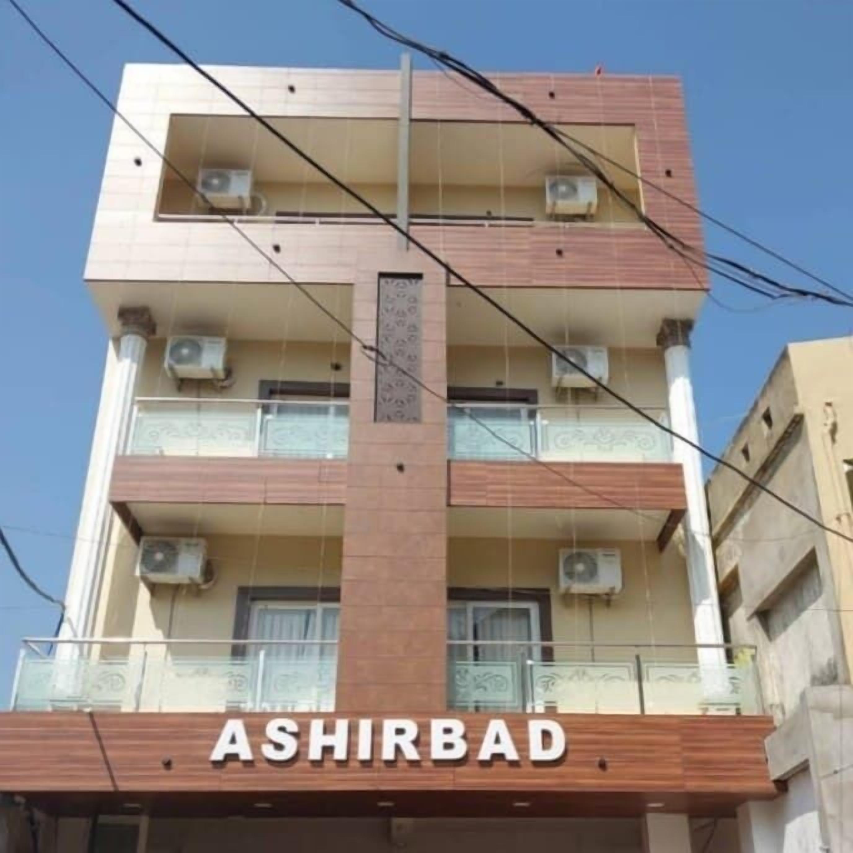 A multi-story building with the name "ASHIRBAD" on the ground floor.