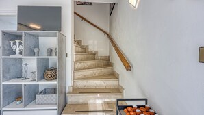 A staircase with a wooden handrail and a white wall with a flat-screen TV mounted above it. - Haven Near The River (Duga Resa)