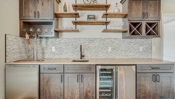 A modern kitchen with wooden cabinets, stainless steel appliances, and a marble backsplash.